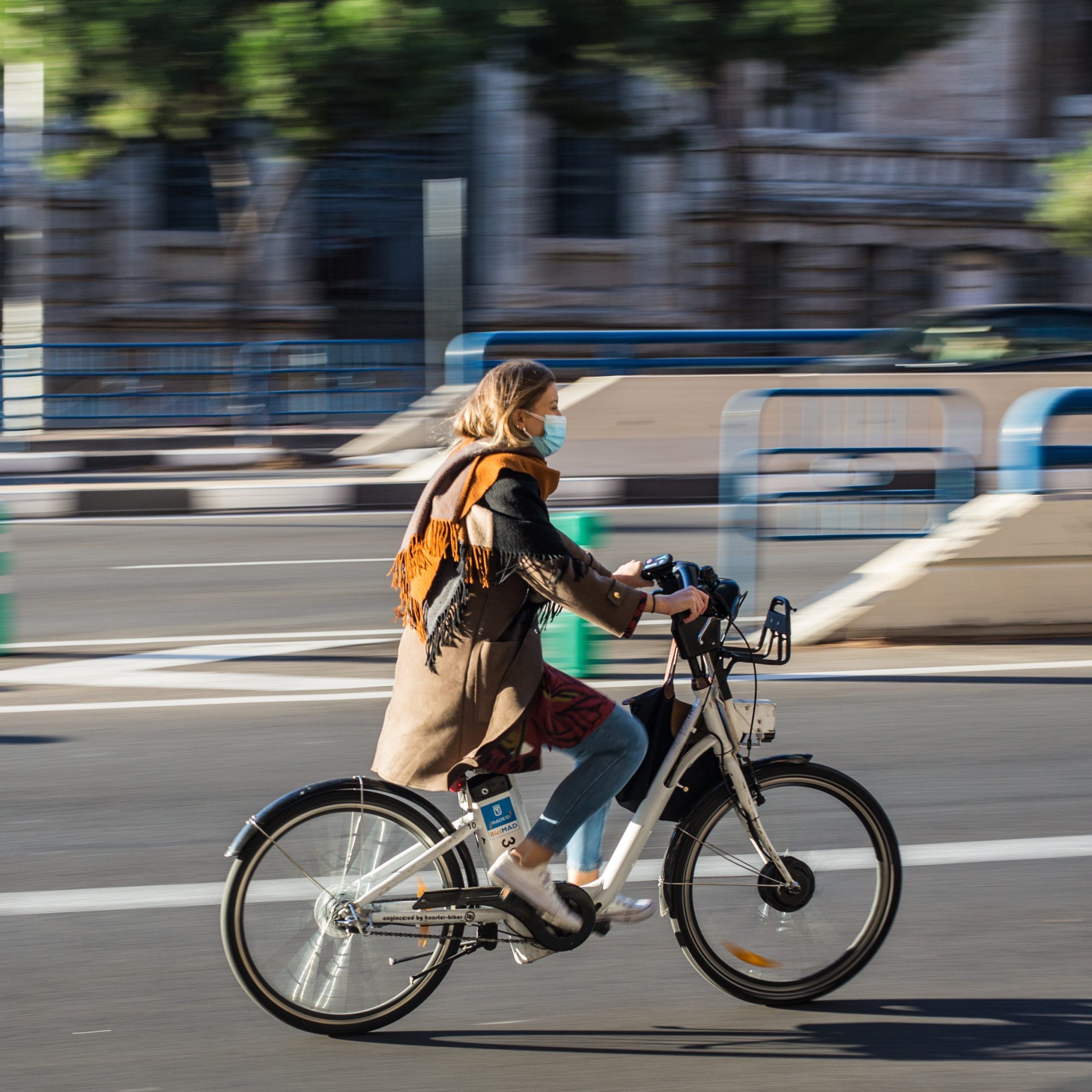 Fille avec un manteau sur un vélo en ville